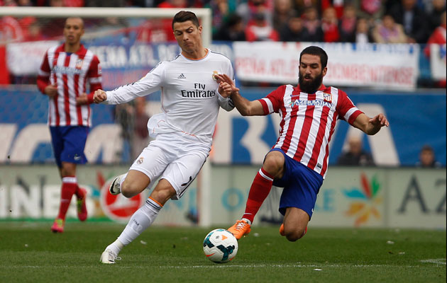 Real's Cristiano Ronaldo, left, in action with Atletico's Arda Turan